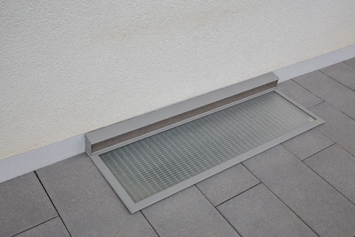 RESI-Lichtschachtabdeckung mit transparenter Platte und Belüftungselement vor einer Hauswand